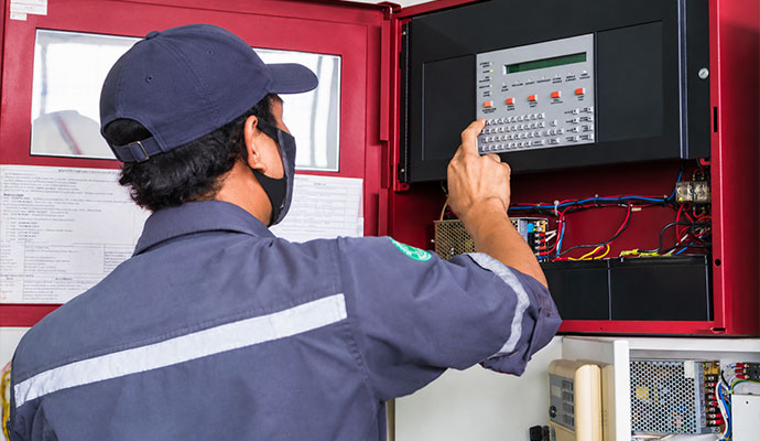 Technician configuring fire alarm control panel