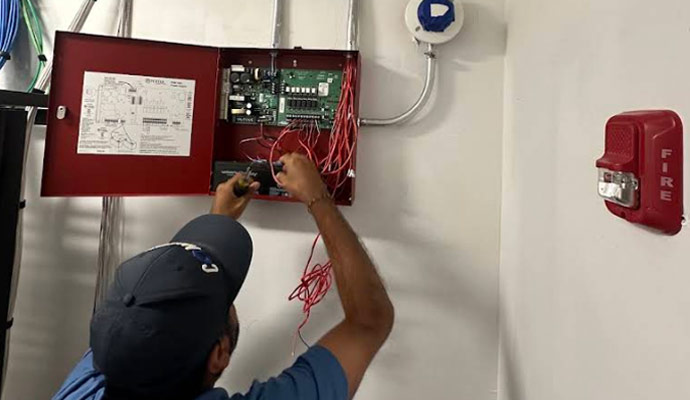 Technician installing fire alarm system